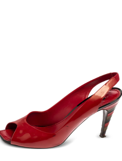 Stylish red patent leather heels featuring a sleek slip-on design, elegant ankle strap, square open toe, branded insole, and a high tapered heel for a bold, sophisticated finish.